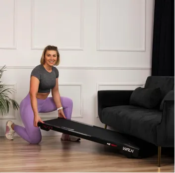 Walking Pad в современном интерьере гостиной, сложенный возле дивана